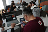 Group of people in a workshop setting, installing RedClaw AI software on laptops with staff guidance. Beijing, 2026.