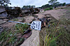 Flood debris, including a bent speed limit sign, lies along the Guadalupe River in Kerrville, Texas.