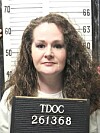 Christa Pike holds a TDOC identification board before a height chart.